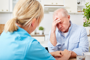 Nurse attempting to communicate with elderly man with dementia